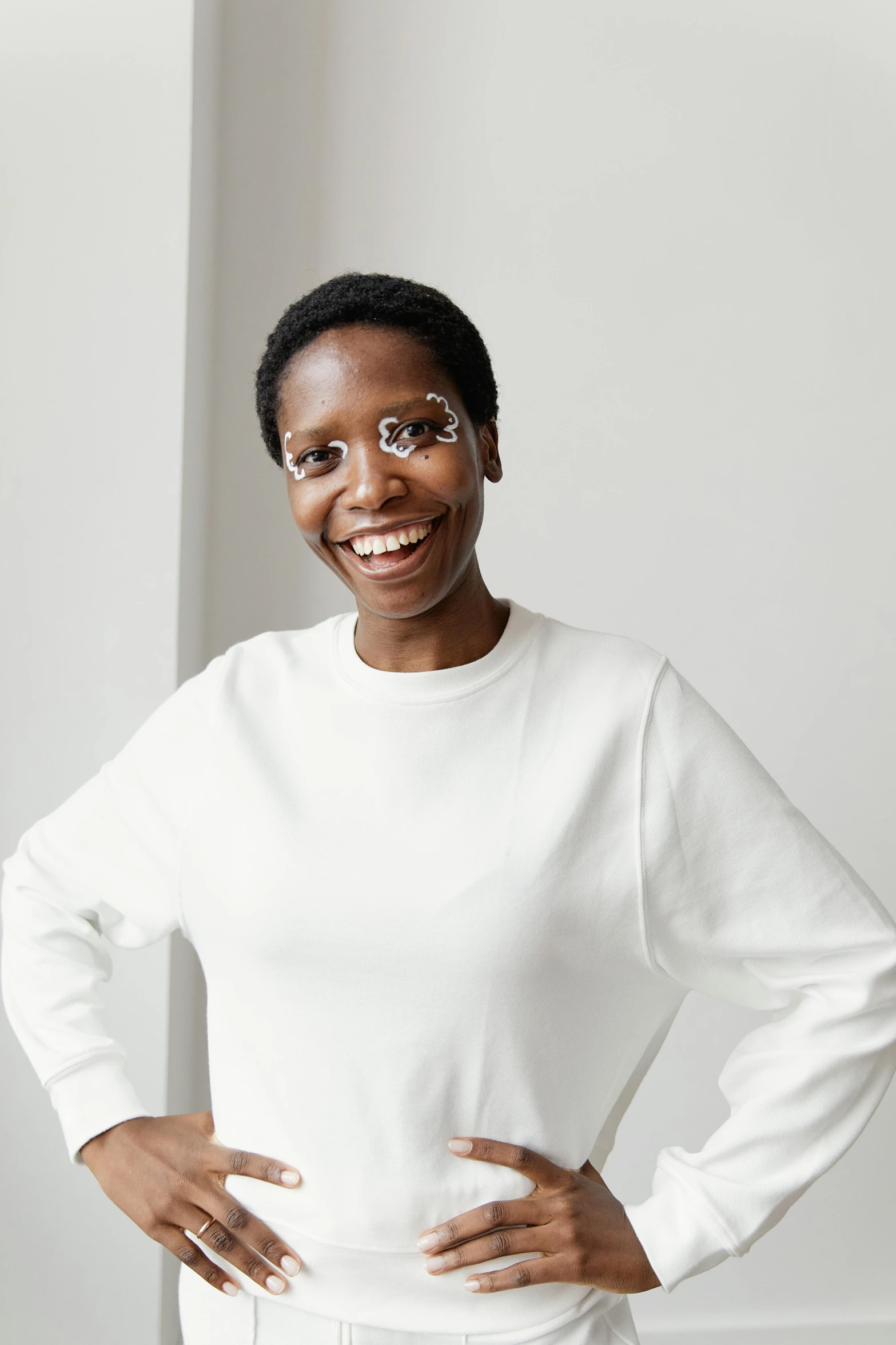 a woman wearing a white sweater standing and smiling