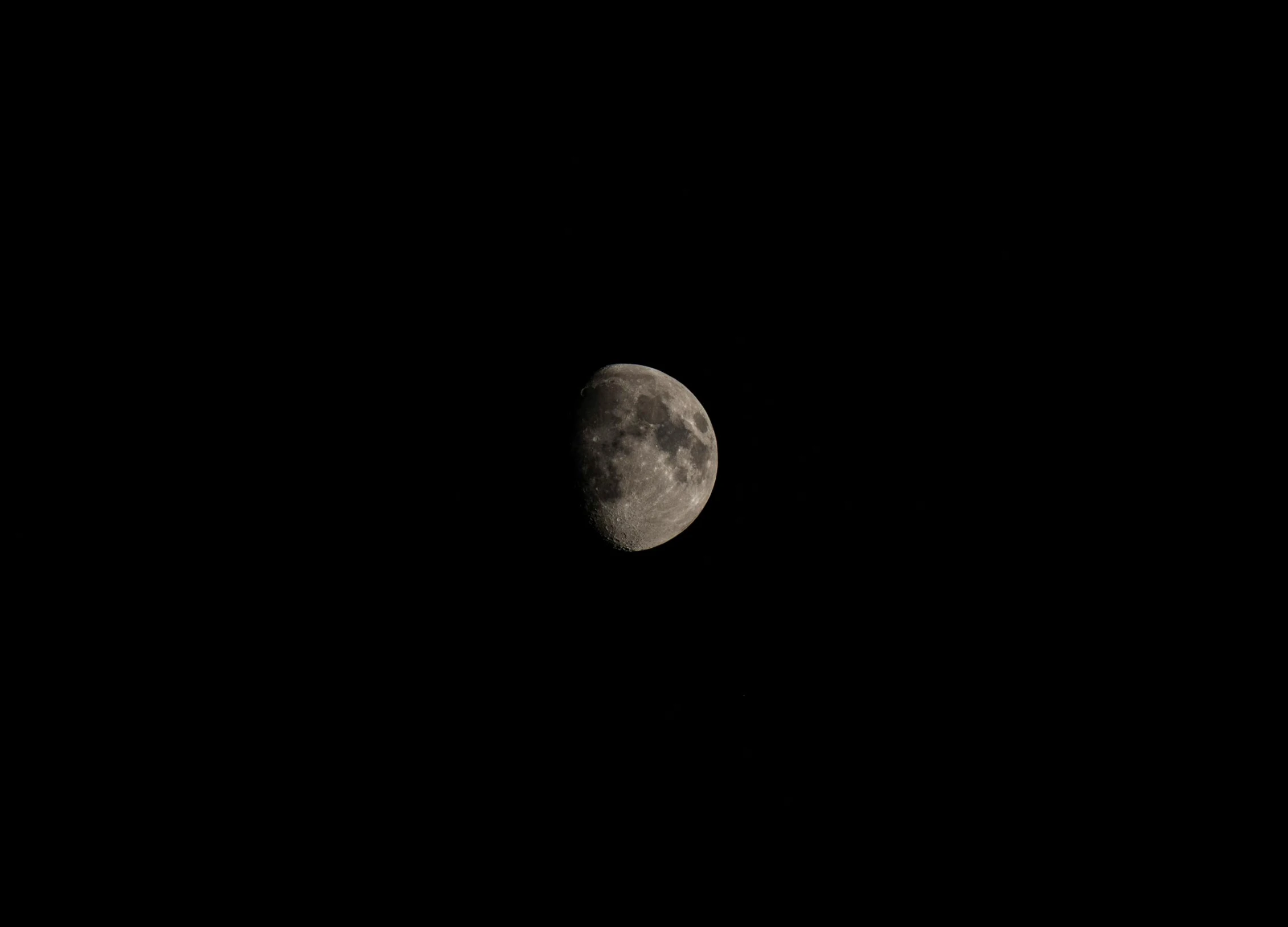 a dark image of the moon in the distance