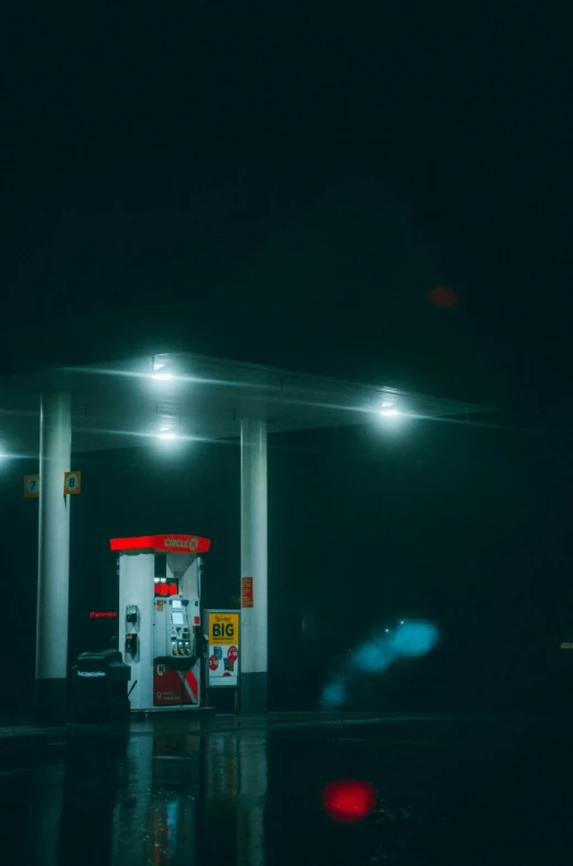 a gas pump in the dark of night with lights on