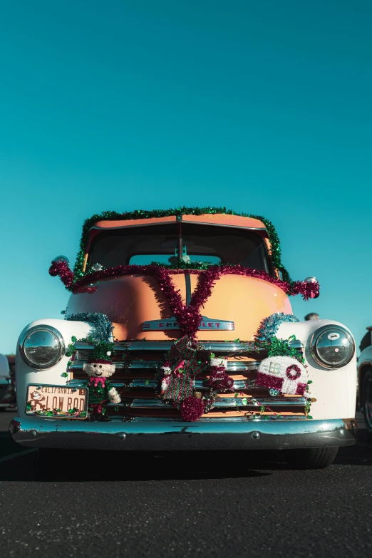 an old fashion white pickup truck decorated with christmas garland and wreath