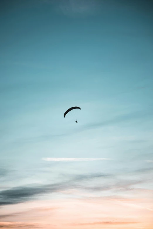 two kites flying high into the sky during a sunset