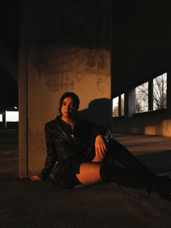 a woman is sitting on the ground while posing for a po