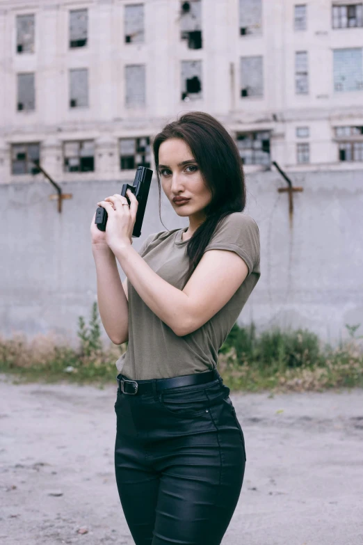 a pretty young lady holding a camera in one hand and a camera in the other