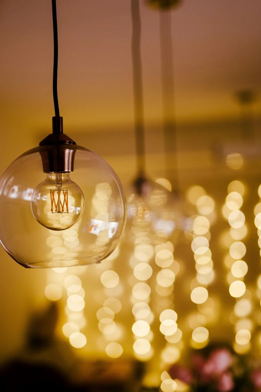 an open lit bulb hanging with lots of blurred lights