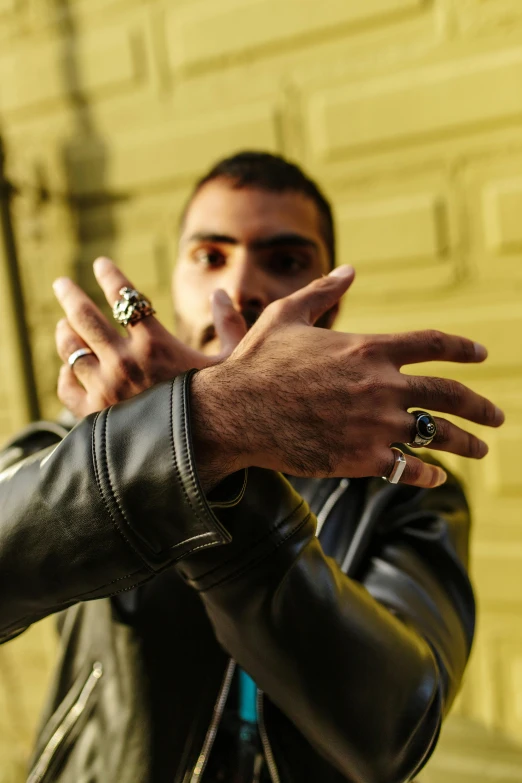 a man with rings on his fingers holding a cigarette