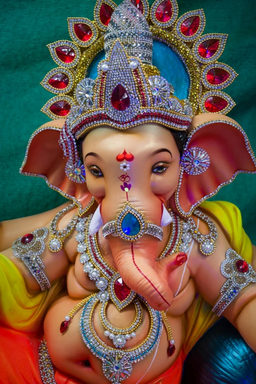 the statue of an elephant with colorful jewelry on its face