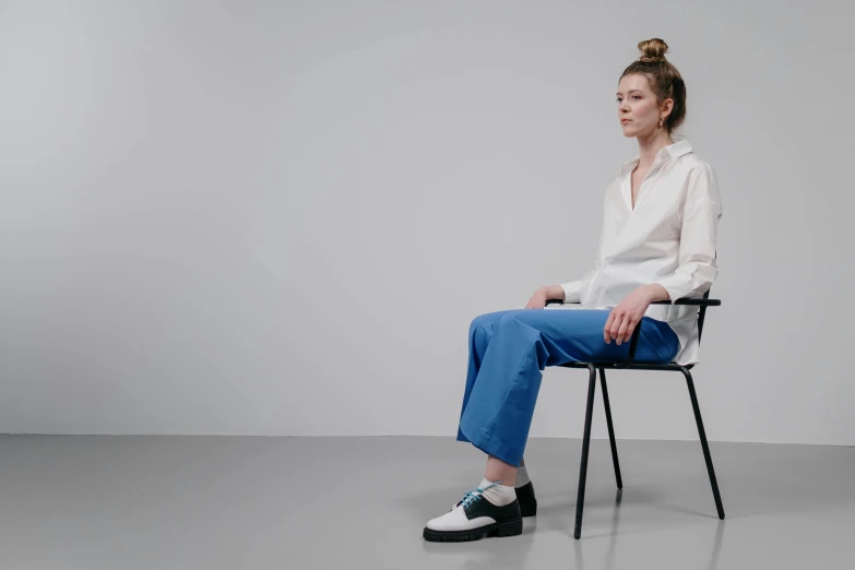 a woman sits in a chair looking away from the camera