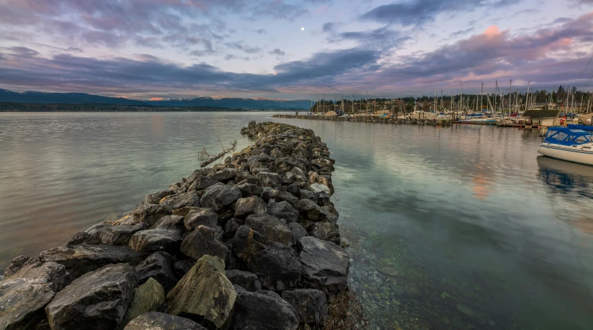 the lake is surrounded by rocks and is reflecting it's colorful hues