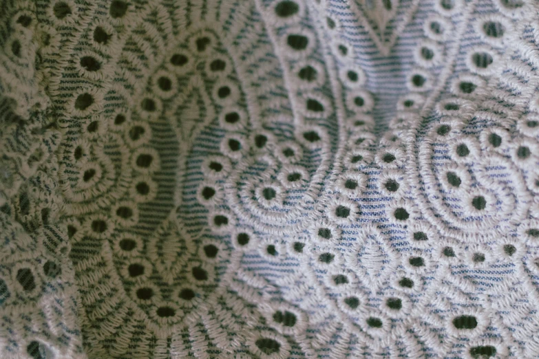 a large white shawl with small holes in the middle