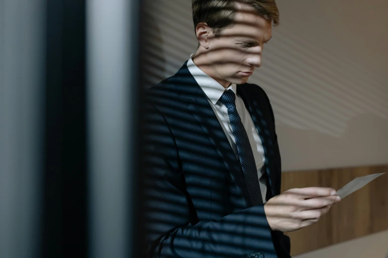 a person holding a paper and wearing a suit