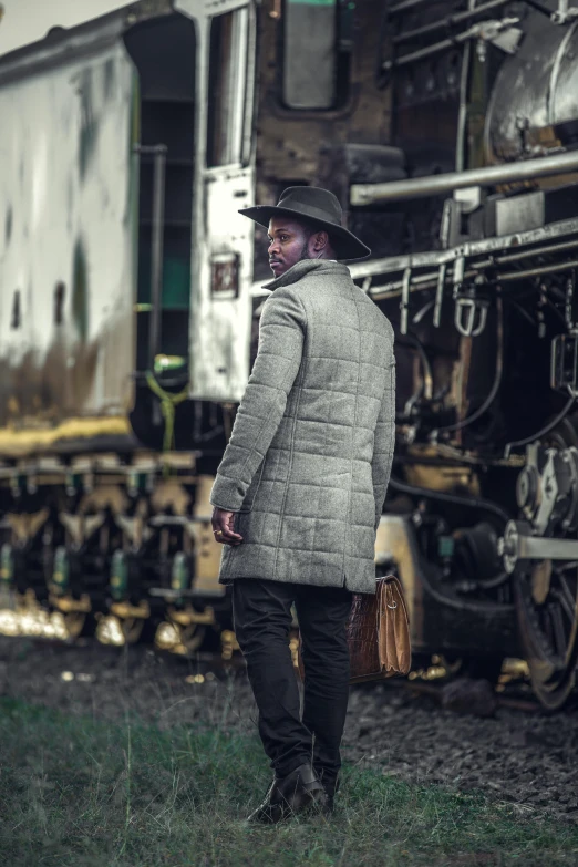 a man standing in front of an old fashioned train
