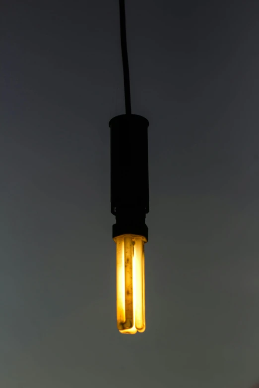 two yellow glowing lights hanging from a black wire