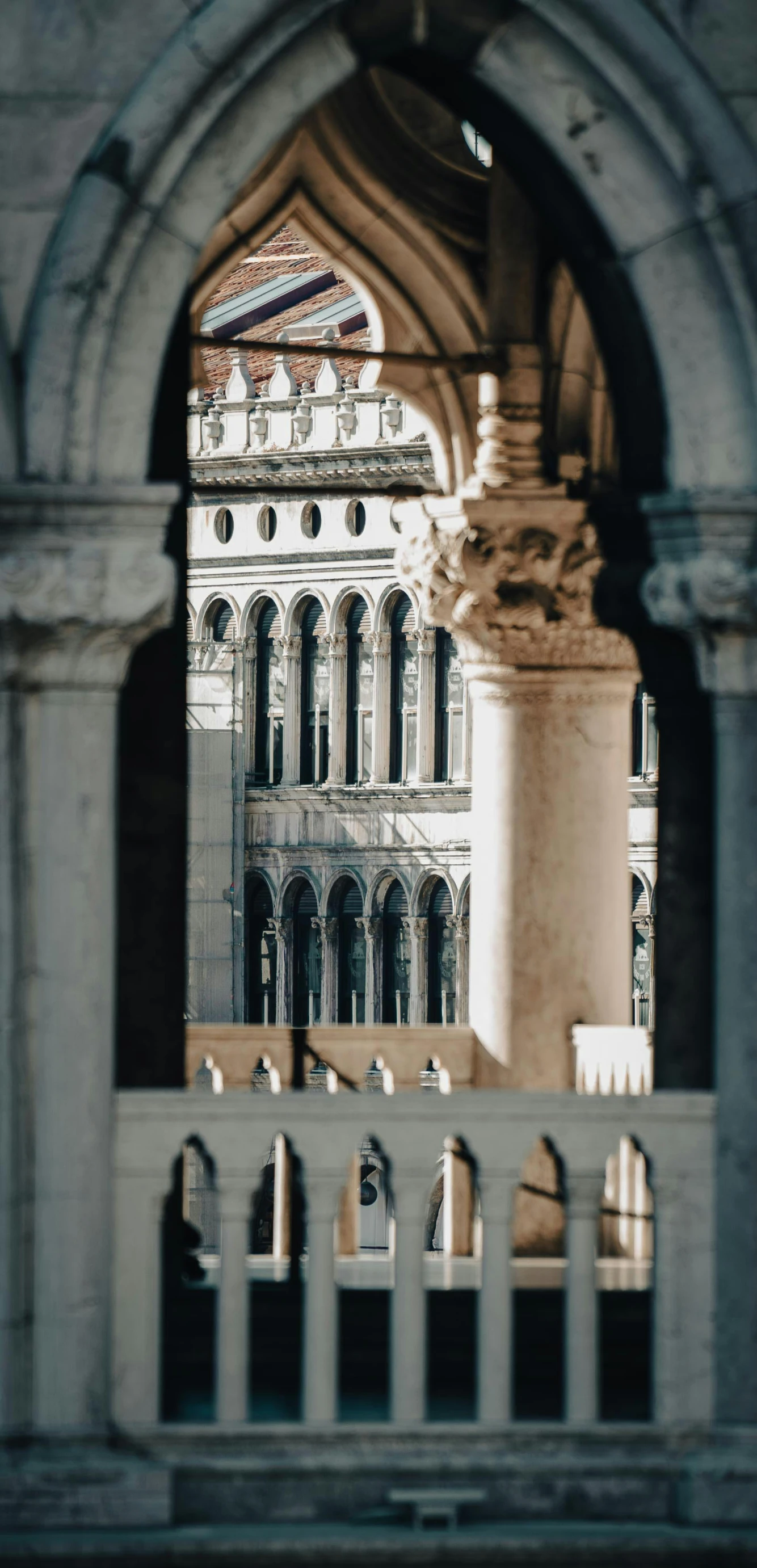 an arch at the base of a building showing a clock and other details