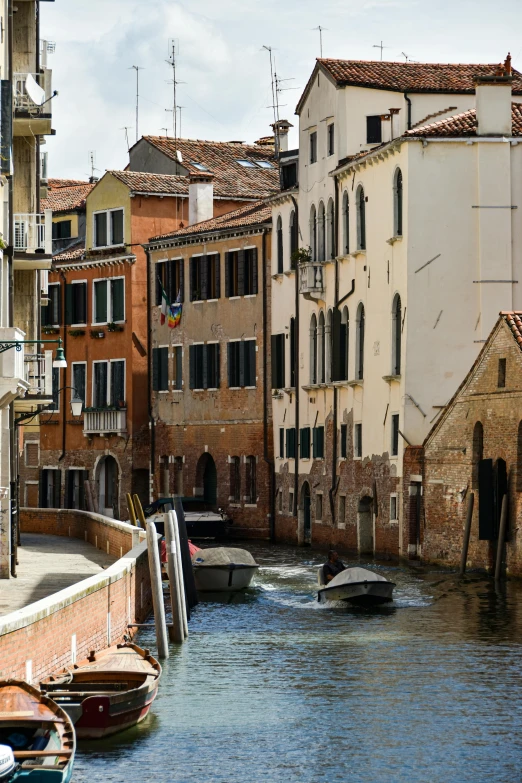 a small canal runs past a line of old buildings