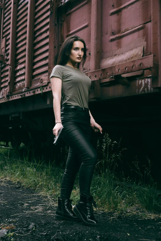 a woman stands in front of an abandoned train