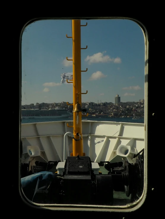 the view from inside a ship looking at the water and a city