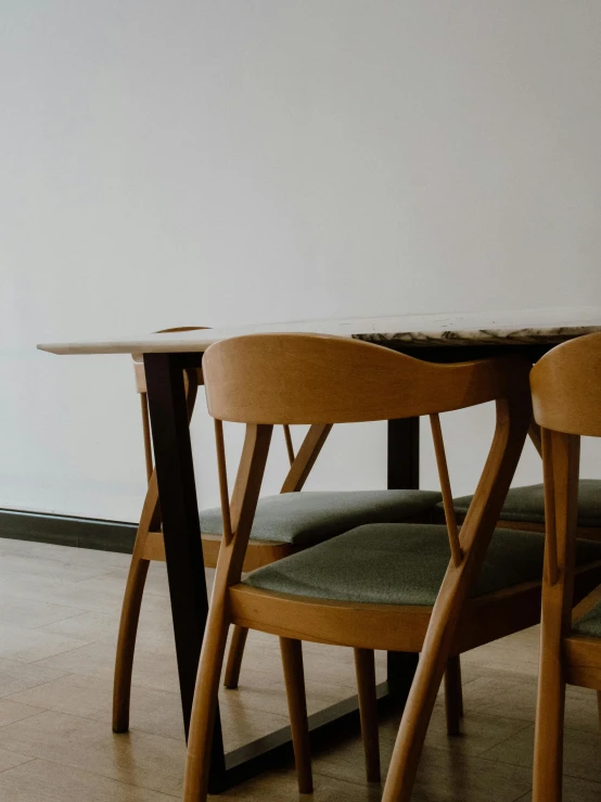 a set of three wooden chairs and a table