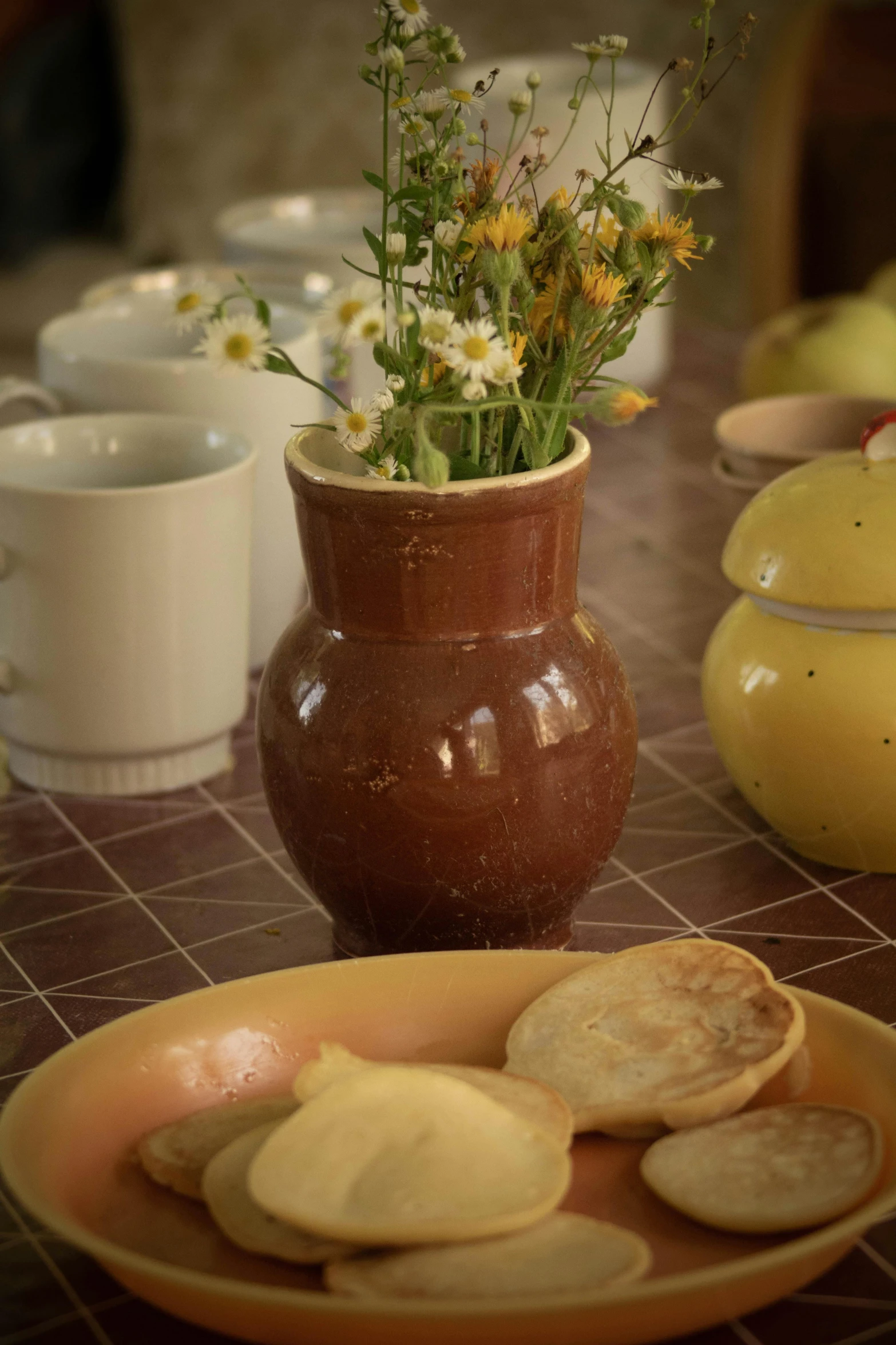 the plate has a plant in it, and a cup of coffee and some snacks