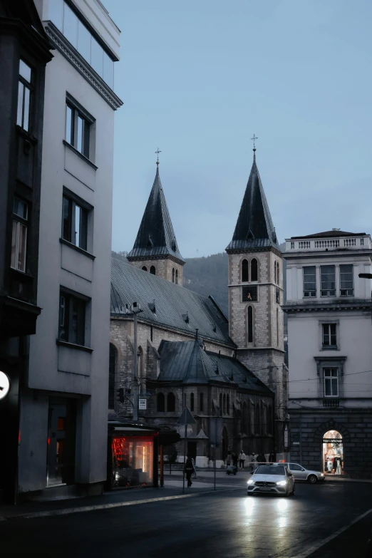 two cars in front of buildings and a clock tower