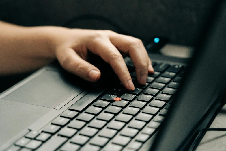 person using their hand on a laptop keyboard