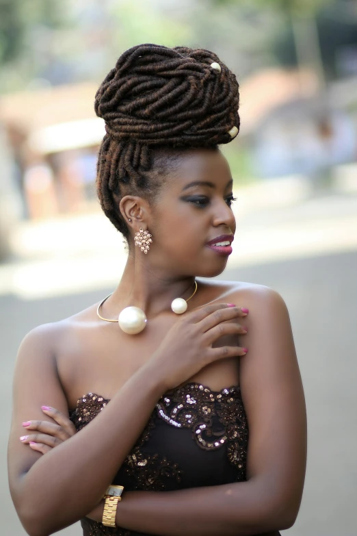an african american woman wearing a brown top and pearls