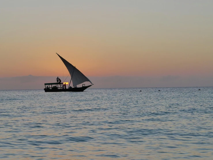 a sail boat on the ocean with people on it