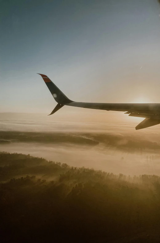 the view from inside an airplane looking down on fog and the engine