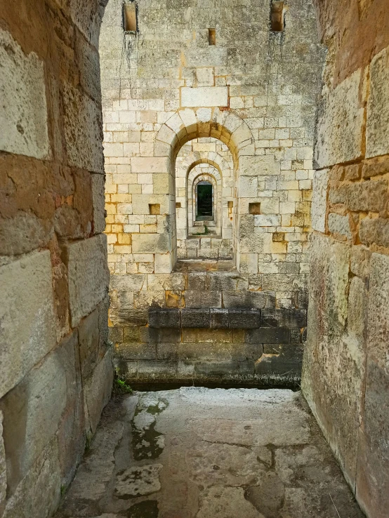 a brick building with stone pillars, doors and windows