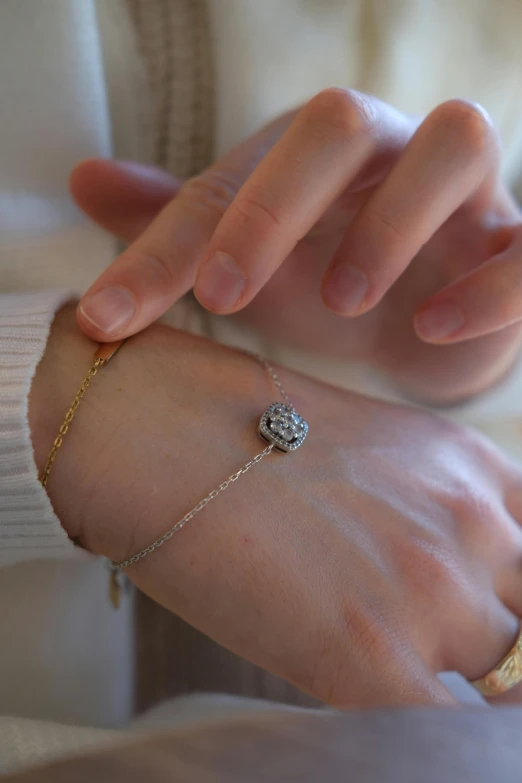 the woman is holding her hand together and wearing a diamond celet