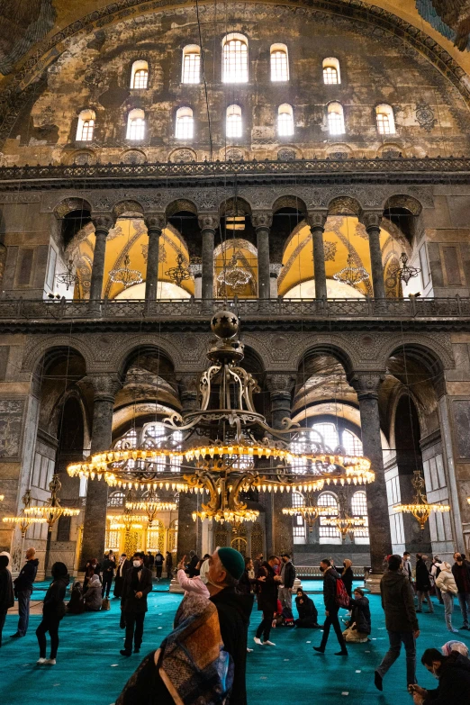 large group of people standing and sitting inside an ornate building