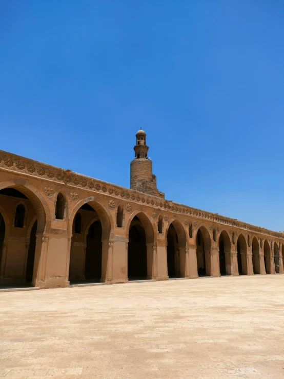 a brick structure with a clock tower is in the middle of a desert landscape