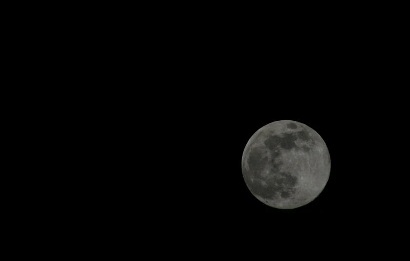 the moon on the black sky during an overcast day