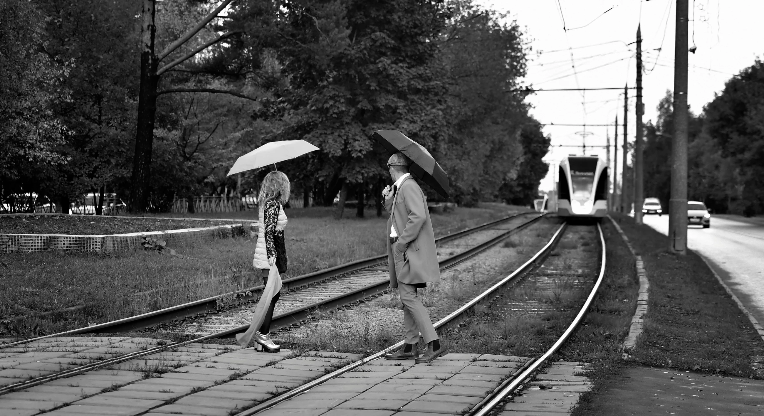 two people walking in the rain with umbrellas