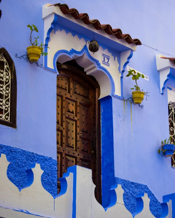 an open wooden door in front of a blue wall with decorative windows