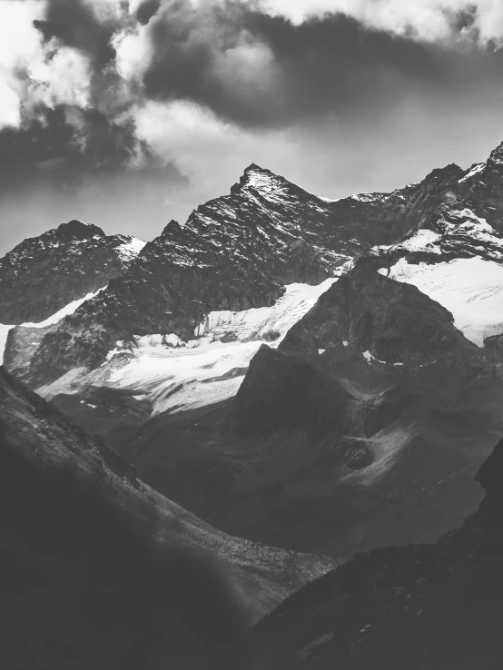 the mountains are covered with snow and clouds