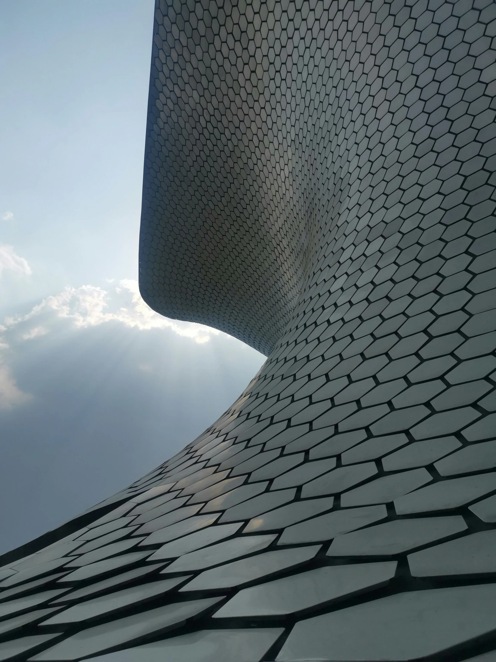 the view from below of an abstract building with a sky background