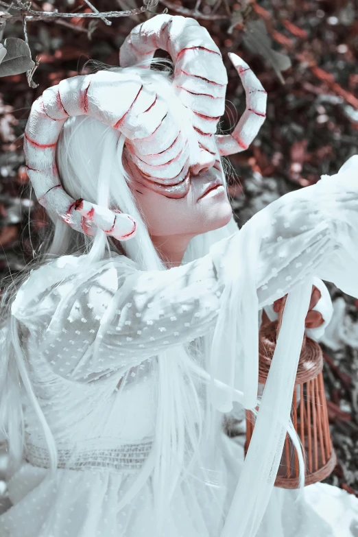 the woman wearing white makeup and headdress wears a strange mask