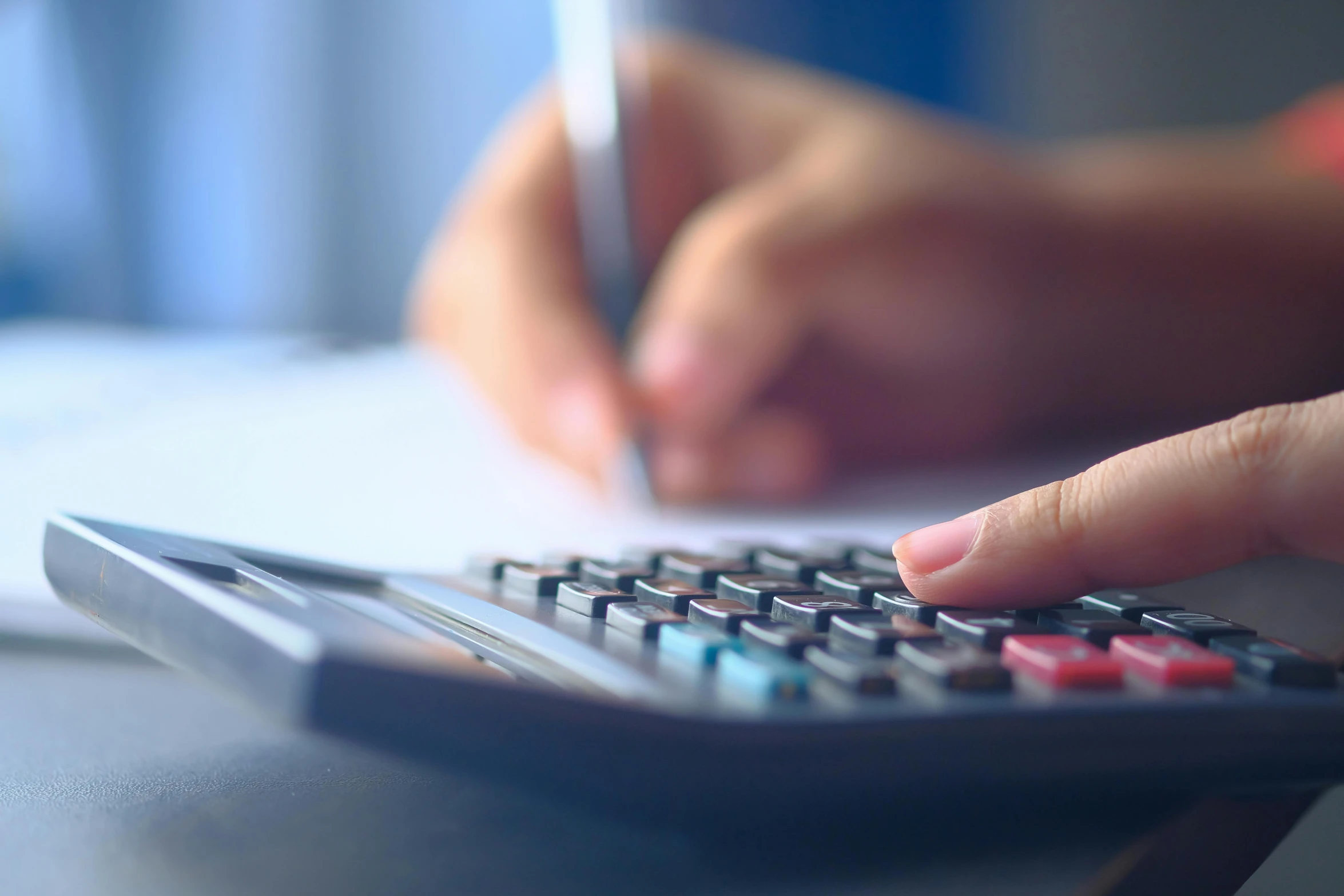 a woman using a calculator to fill out her bills