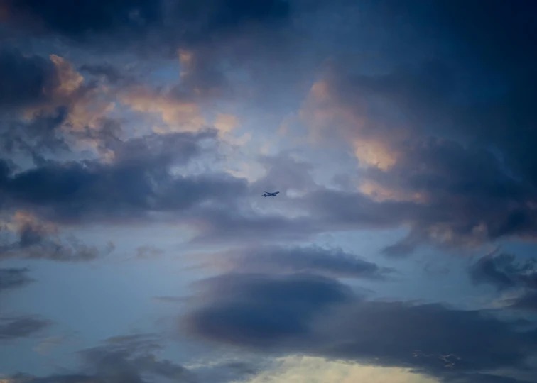 the sky at dusk with an airplane flying