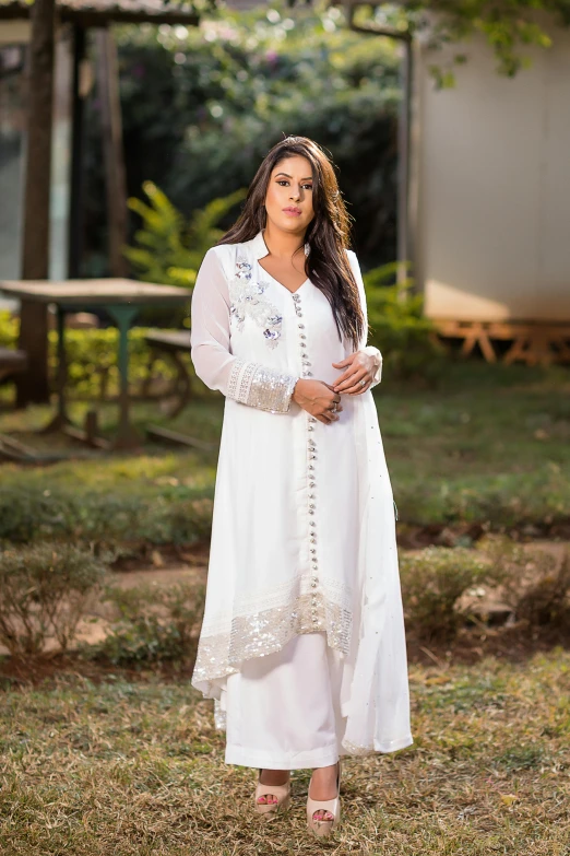 a woman is dressed in white clothes, standing outside