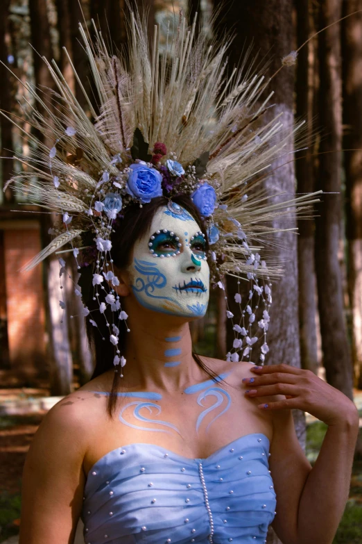 a woman is dressed in an elaborate mask and white makeup