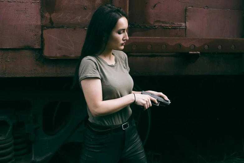 a girl standing next to a train holding onto her phone