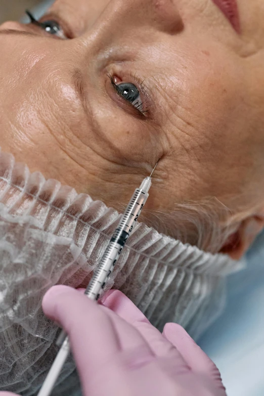 a female in a surgical suit is getting her eye examined