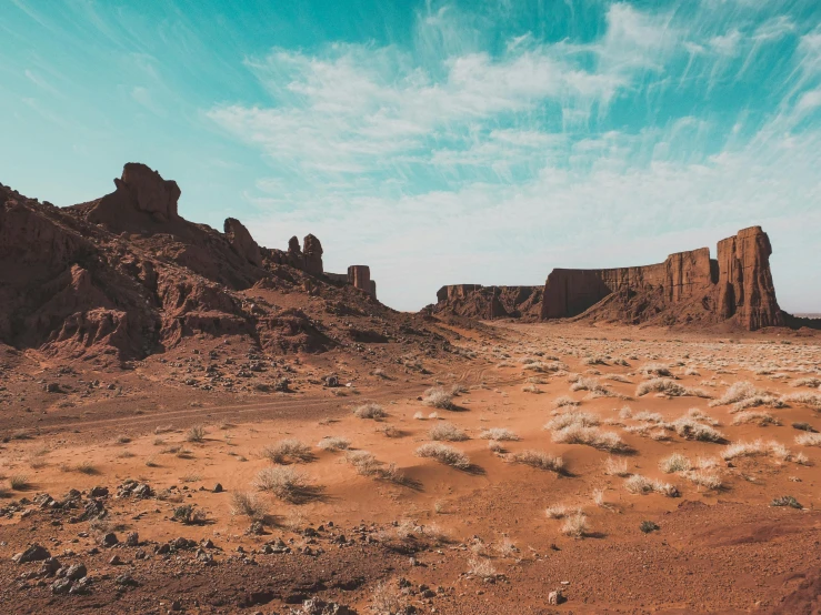 two rock formations are in a barren desert area