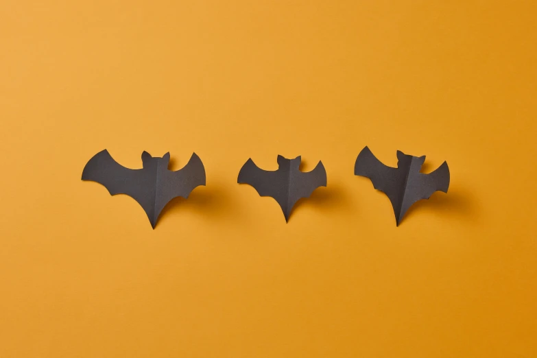 three pieces of paper with bats on a yellow background