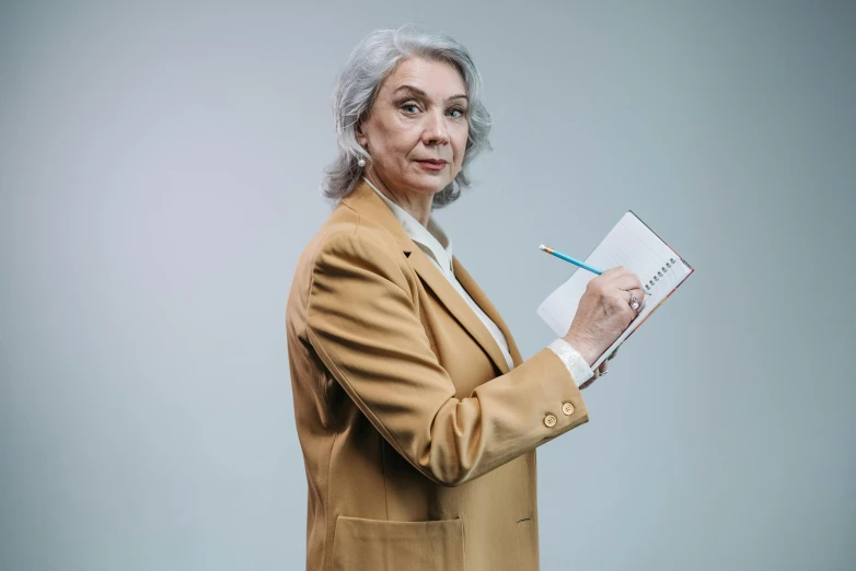 an older woman is holding papers and pencil