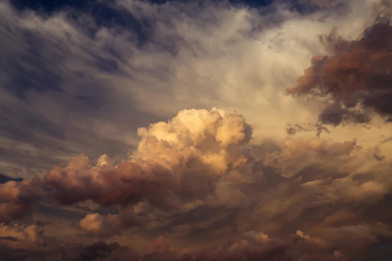 an airplane flying through a cloudy sky with a few clouds