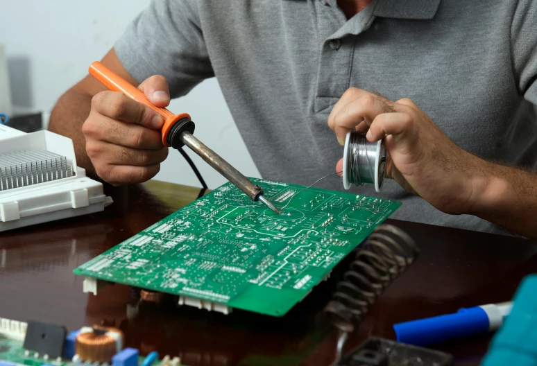 a man working on a piece of electronics and tape