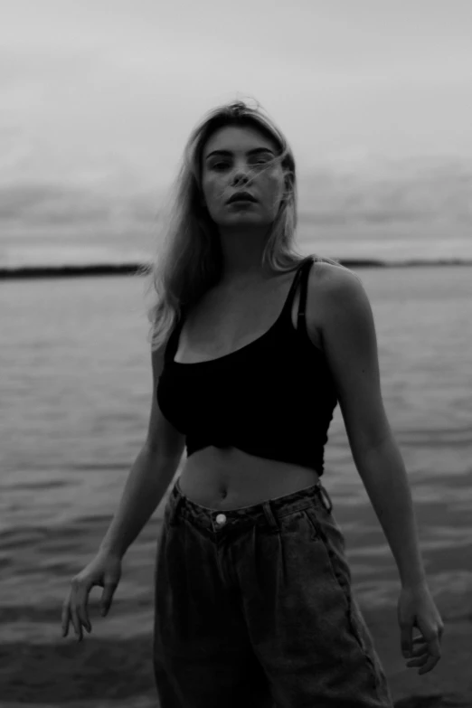 a woman posing by the water in front of the beach