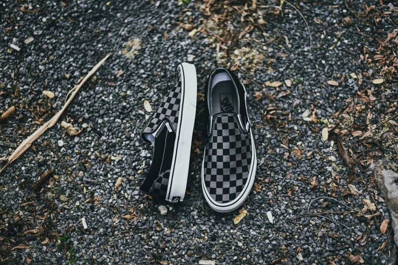 a pair of checkered tennis shoes on asphalt